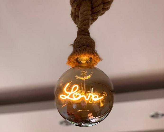Moderní žárovka se světelným nápisem Love zavěšená na laně